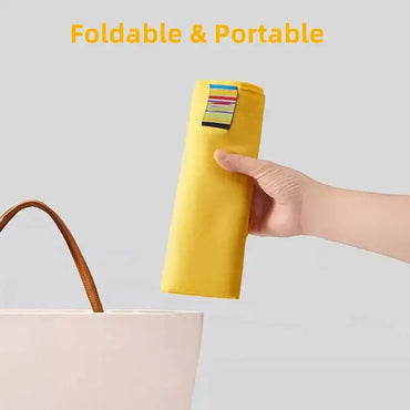 Person holding a foldable and portable child seat harness in yellow, ideal for travel and dining with toddlers.